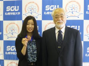 銅メダルを学長に説明する藤本さん